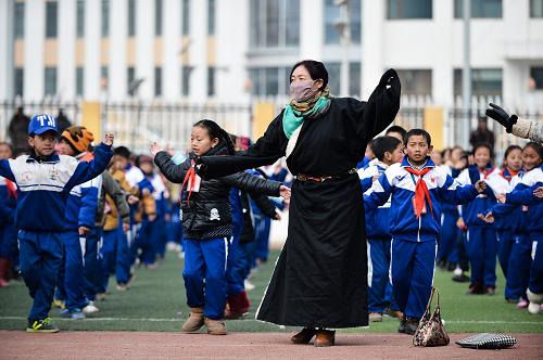 3月10日,玉树市第一完全小学的老师在课间领学生们跳锅庄。新华社记者 吴刚 摄