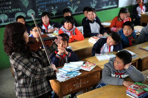 3月11日,志愿者伊明(左一)在给小学生上音乐欣赏课并演奏小提琴。当日,由西安市青少年宫和西安市文明办联合组织的文化志愿者团队,来到周至县竹峪镇兰梅塬小学,给小学生教授小提琴、书法、绘画、舞蹈等课程,为孩子们带来新的艺术知识和欢乐。新华社发(侯智 摄)