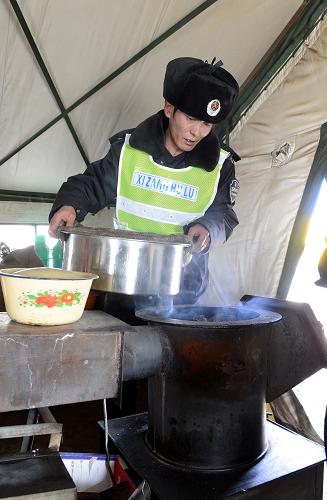 护路人员在帐篷里用牛粪作燃料烧饭(3月13日摄)。新华社记者 觉果 摄