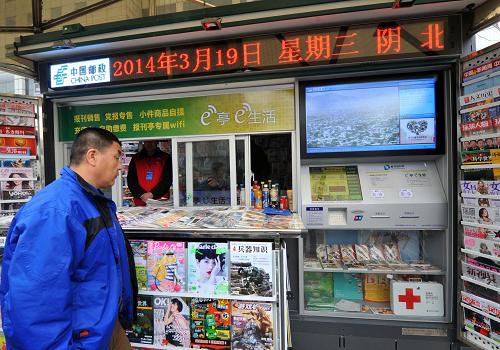 3月19日,一位市民在观看智能报刊亭。当日,北京邮政打造的智能报刊亭正式亮相。智能报刊亭运用先进的数字网络技术,将传统报刊零售与电子商务、数字发行等现代商业模式对接。与传统报刊亭相比,智能报刊亭的服务功能大大拓展,除纸质报刊、充值卡零售外,还增加了新华视频、自助缴费、小件商品自提、WIFI终端阅读、文化商品展示、外伤救助和气象信息等服务内容。新华社记者 公磊 摄