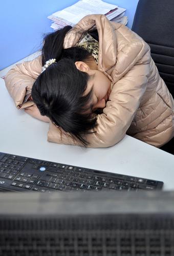 3月21日,在河北省邯郸市一单位,一名离家较远的员工在办公桌上午休。新华社发