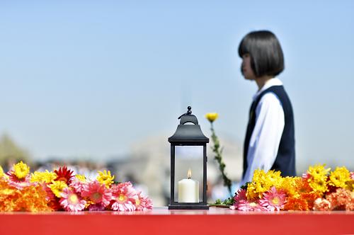 4月4日,一名小学生在“2014清明祭先贤 放飞梦未来”主题活动现场献花祭先贤。新华社发(王京生 摄)