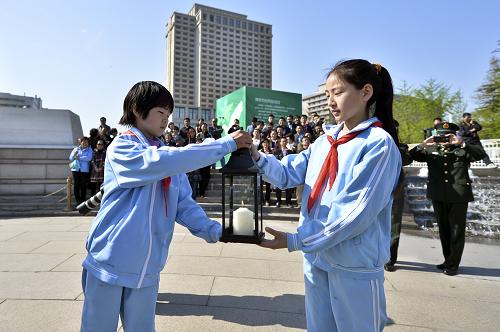 4月4日,来自香山小学的学生在“2014清明祭先贤 放飞梦未来”主题活动现场传递薪火火种。新华社发(王京生 摄)