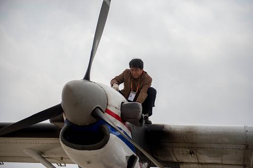 4月4日,朱海中航通用航空公司的机务人员检查实施增雨作业飞机的发动机。新华社发(胡超 摄)