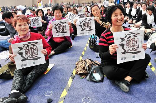 4月13日,参加活动的西安市民展示自己书写的汉字“BIANG”。新华社发(袁景智 摄)