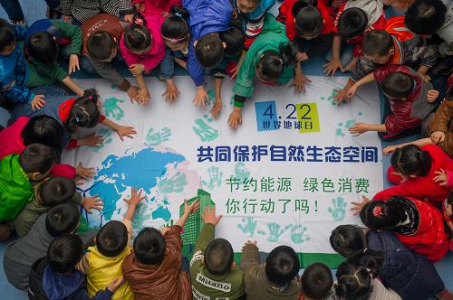 4月21日,合肥市天鹅幼儿园的小朋友在主题画布上按手印。新华社记者 杜宇 摄