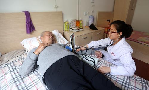 4月21日,养护中心护士何骥在为一位老人测量血压。新华社记者 姚剑锋 摄