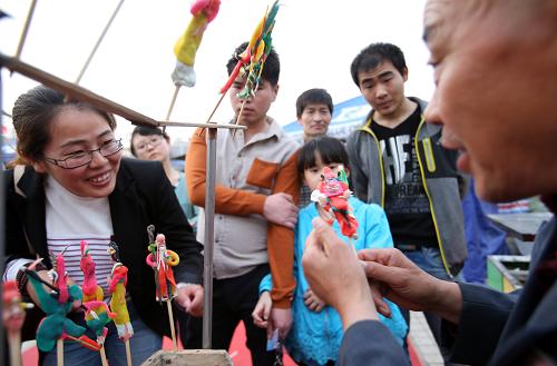 4月21日,董金龙在街头现捏现卖他的面塑作品。新华社发(鲍东升 摄)