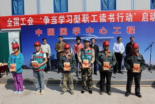 4月22日,北京城建集团中国国学中心项目基地的工人们在启动仪式上领取书籍。新华社记者 何俊昌 摄