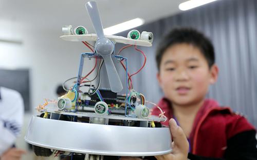 4月22日,一名学生在展示制作的“灭火机器人”。新华社发(张驰 摄)