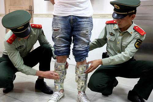 4月23日,嫌疑男子将现金用胶带绑在身上入关时被查获。新华社发(王须摄)
