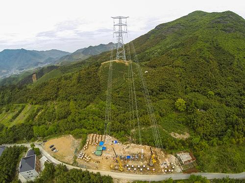 4月23日,施工人员在铁塔间架线。新华社记者徐昱摄