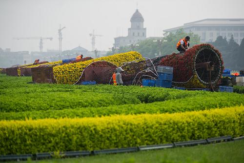 4月23日,工人在北京天安门广场西侧绿化带摆花。新华社记者罗晓光摄