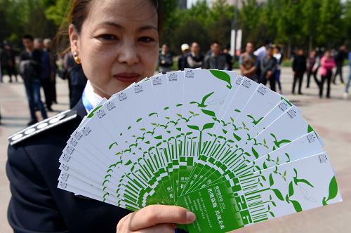 4月24日,一位工作人员在展示“绿书签”。当日,山东省和济南市“扫黄打非”工作领导小组在济南市泉城广场集中销毁了一批侵权盗版及非法出版物,全省共销毁164万余件。2014年以来,山东省各级“扫黄打非”工作部门共出动执法检查人员9.4万多人次,检查经营出版物店档摊点2.8万个次,检查印刷企业1.9万家次,共查缴各类非法盗版出版物31万余册(盘),清理取缔无证无照非法流动书摊和不法游商640余个,查处各类违法违规案件370余起。新华社发 (朱峥摄)