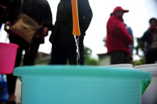 4月24日,在武汉东西湖区余氏墩水厂附近的汉江康居还建小区,居民在排队接水。新华社记者肖艺九摄