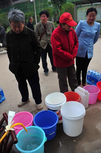 4月24日,在武汉东西湖区余氏墩水厂附近的汉江康居还建小区,居民在排队接水。新华社记者肖艺九摄