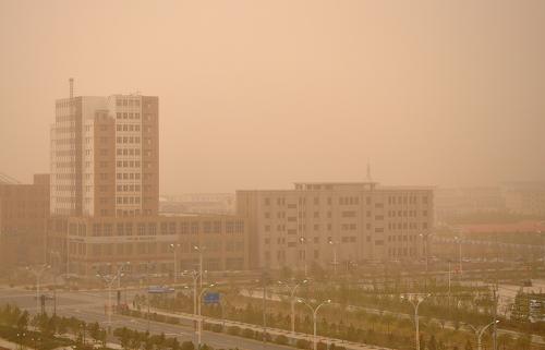4月24日,内蒙古自治区巴彦淖尔市乌拉特中旗遭遇大风沙尘天气。这是沙尘笼罩下的海流图镇。新华社发(支茂盛 摄)