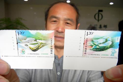 4月25日,一名集邮爱好者在苏州邮政局展示刚购买的《2014青岛世界园艺博览会》纪念邮票。新华社发(王建康 摄)