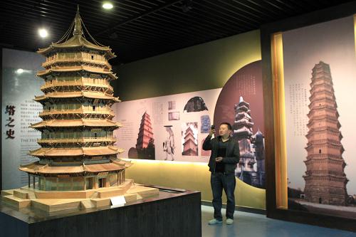 4月28日,参观者在河南许昌塔文化博物馆拍摄山西应县木塔模型。当日,以研究和展示塔文化为主题的博物馆——河南许昌塔文化博物馆开馆,向公众免费开放。该博物馆占地面积14000平方米,有2000多件以塔为主题的文物、照片、模型等展品。新华社发(牛书培 摄)