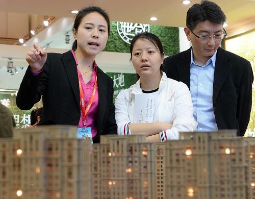 4月30日,工作人员在上海“五一假日楼市”上向市民推荐楼盘。当日,“五一假日楼市”2014上海房展会在上海市展览中心开幕,200多家房地产开发商、代理商及移民机构参展,集中展示了500多个房地产项目。房展会将持续至5月3日。新华社发(赖鑫琳 摄)