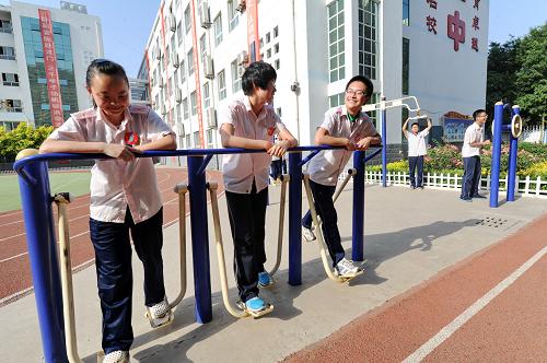 5月29日,在河北省衡水市第十三中学操场上,高三学生们在利用健身器材锻炼身体,舒缓心情。