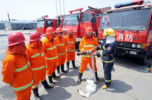 6月3日,霸州市消防队官兵在为霸州市王圪垯村消防联防队培训。河北省霸州市王圪垯村是一个板材生产专业村,全村有木材加工企业近500家,由于村子离市区较远,一旦失火专业消防队很难及时赶到。为此,村里和几个大企业共同出资购买了6辆专业消防车,企业工人兼职消防队员,组成了一个消防联防队。新华社记者 李晓果 摄