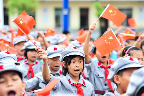 6月3日,在授旗授牌仪式上,康克清红军小学的学生在挥舞国旗。新华社记者 李琰 摄