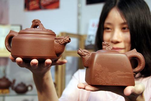 6月6日,来自江苏宜兴的紫砂艺人蒋春音在茶博会现场展示“龙腾盛世”紫砂对壶。新华社发(黄金华 摄)