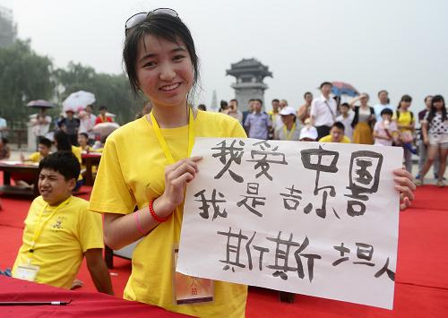 6月15日,一名参加夏令营的东干少年展示自己刚刚写好的汉字。新华社记者 刘潇 摄