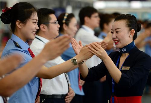 6月18日,在兰州中川机场,东方航空甘肃分公司地面服务人员(右一)为兰州火车站高铁客运员指导礼仪动作。当日,兰州火车站首批12名高铁客运员来到兰州中川机场,与东方航空甘肃分公司地面服务人员进行业务交流,学习民航的先进管理方式和服务经验。据悉,连接甘肃、青海、新疆的兰(州)新(疆)第二双线高速铁路全长1776公里,预计2014年年底通车。新华社记者 张锰 摄