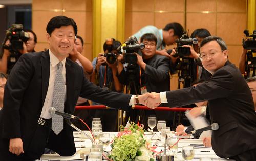 7月14日,中国商务部部长助理王受文(前右)和韩国通商产业资源部部长助理禹泰熙(前左)在谈判前握手。当日,中韩自贸区第十二轮谈判在韩国举行。双方将就货物贸易、服务贸易、投资、原产地规则、贸易救济、技术性贸易壁垒、卫生和植物卫生措施、知识产权等领域开展磋商。中韩自贸区谈判于2012年5月正式启动,现已完成模式阶段谈判。双方领导人已于近日共同宣布,将进一步努力在年底前完成谈判。新华社 发