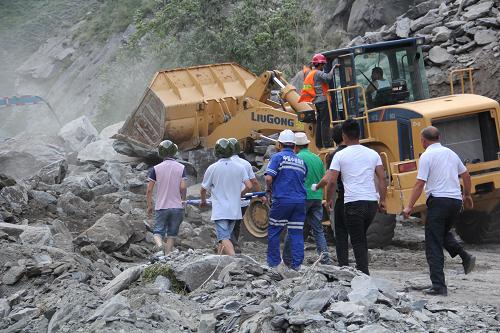7月17日,救援人员在塌方现场疏通道路。新华社发(四川茂县县委宣传部 供图)