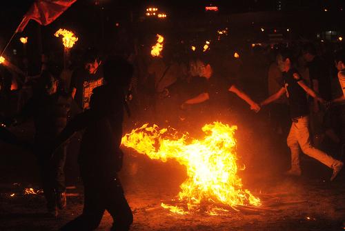 7月20日晚,彝族群众和外地游客围着篝火舞蹈。新华社记者 蔺以光 摄