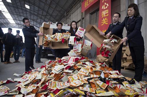 3月12日,杭州出入境检验检疫局工作人员将不合格进口商品集中等待销毁。当日,杭州出入境检验检疫局集中销毁了近期查获的3批次共100多箱不合格进口食品。食品包括膨化食品、饼干、果干、烘培坚果类,涉及违法添加食品添加剂、微生物超标等。2014年,杭州出入境检验检疫局共检出涉及安全、卫生项目不合格进口食品30批。据介绍,涉及安全、卫生项目不合格的食品必须监督销毁或退运,不得进入流通领域。新华社记者 鞠焕宗 摄