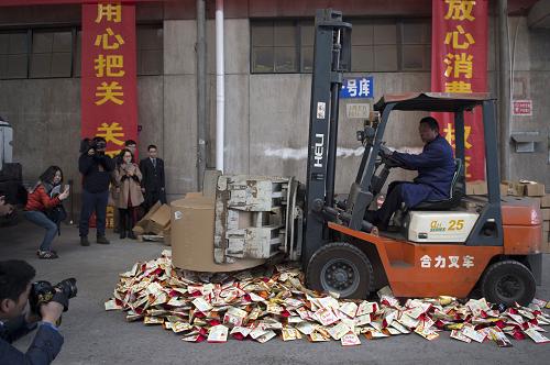 3月12日,一名工作人员将不合格进口商品进行碾压销毁。新华社记者 鞠焕宗 摄