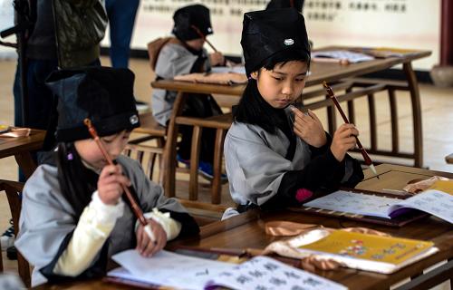 3月21日,孩子们身着古代传统服饰,学写毛笔