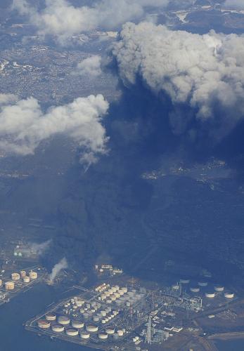 3月12日,日本宫城县仙台港上空升起黑烟。 日本东北部地区11日下午发生里氏8.8级强烈地震,引发大规模海啸并造成重大损失。 新华社/共同社