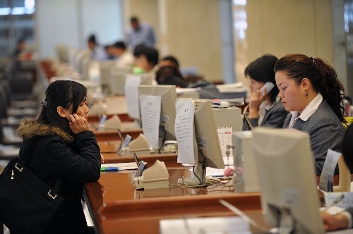 一名女士(左)在天津市行政许可服务中心向工作人员咨询(12月12日 )..