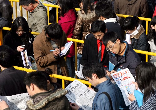 2月23日,在上海体育馆外,排队等待进入招聘会场的求职者在了解招聘信息。当日,多场大型招聘会分别在上海虹口足球场、上海展览中心等地举行,约有数千家用人单位提供了上万个工作岗位,吸引众多求职者前来应聘。 新华社记者 刘颖 摄