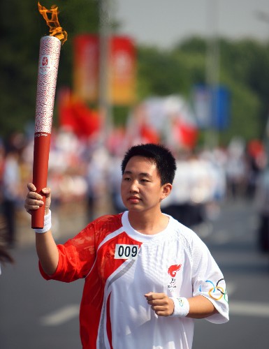 5月18日,火炬手邵林博在进行传递。当日,北京奥运会圣火在浙江杭州传递。新华社记者 邢广利 摄
