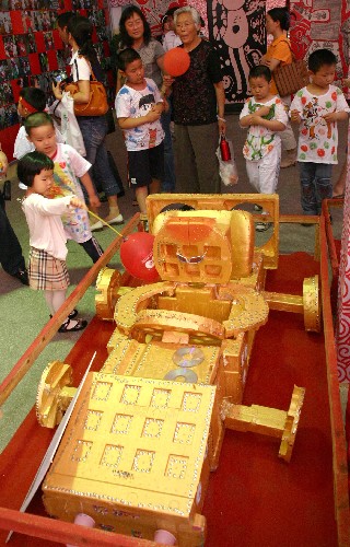 5月31日,小朋友们观看幼儿创意作品《赛车》。 当日,为期三天的“我与奥运共精彩――幼儿美术创意作品展”在南京市青少年宫开幕。展览展示了雨花台区实验幼儿园的小朋友利用生活中的废旧材料创作的千余件奥运题材作品。孩子们通过自己的作品寄托了对北京奥运会的憧憬和梦想,吸引了众多市民前来参观。 新华社发(董金林 摄)