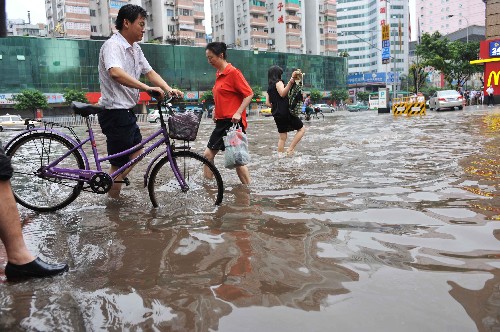 6月14日,几位行人涉水通过广州街道。广东连日来遭受大暴雨袭击。根据《广东省防汛抗旱防风应急预案》,广东省防总于6月13日启动防汛Ⅳ级应急响应。广东省防总已要求各地和各有关部门做好防御工作,确保防洪安全。 新华社记者 壮锦 摄