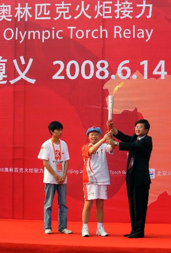 6月14日,在起跑仪式现场,第一棒火炬手、93岁高龄的老红军王道金(中)与遵义市市长慕德贵(右)共同高举火炬。当日,北京奥运火炬传递活动在贵州省遵义市举行。 新华社记者 安治平 摄