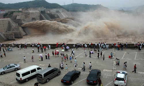 6月29日,游客参观黄河小浪底水库调水调沙。当日,黄河小浪底水库开始排沙,裹挟着泥沙的混浊水流从排沙洞奔腾而出,十分壮观。黄河第七次调水调沙从6月19日开始,通过万家寨、三门峡水库泄量加大,在小浪底水库区形成高含沙水流,人工塑造异重流并排沙出库。 新华社发(苗秋闹 摄)