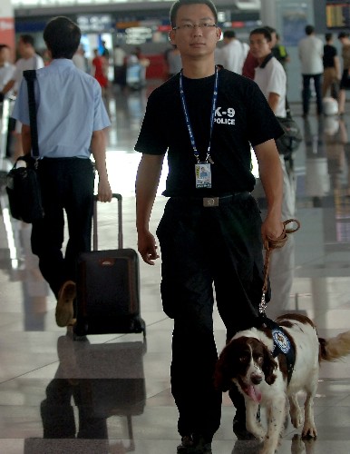 7月20日,一名警察携警犬在首都机场3号航站楼内巡逻。新华社记者 公磊 摄