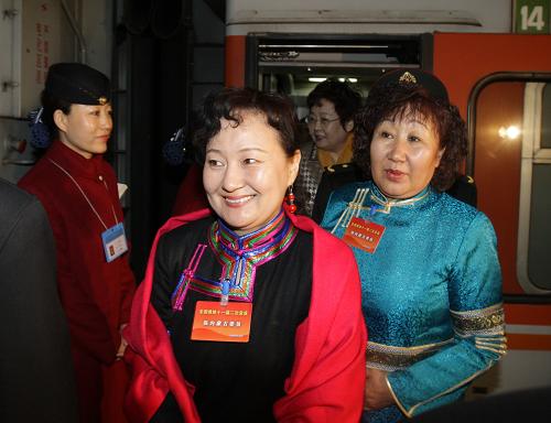 3月1日,来自内蒙古自治区的全国政协委员杜梅(左)和莎娜(右)走下火车。当日,来自内蒙古自治区的全国政协委员抵达北京西站。新华社记者 邢广利 摄