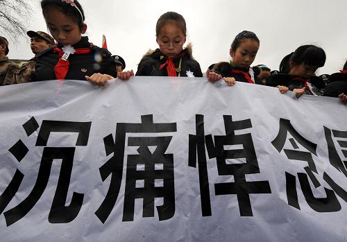12月13日,学生代表在“侵华日军南京大屠杀中山码头遇难同胞纪念碑”前的悼念仪式上默哀。新华社记者 孙参 摄