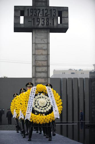 12月13日,武警战士在悼念仪式上为遇难者敬献花圈。 当日,南京各界人士在侵华日军南京大屠杀遇难同胞纪念馆集会广场举行“悼念侵华日军南京大屠杀30万同胞遇难72周年仪式暨南京国际和平日集会”。江苏省、南京市各有关部门、各民主党派、群众代表,南京市学生代表,南京大屠杀幸存者代表,以及来自日本、波兰等国家的友好人士,共约5000人参加了集会。 新华社记者 韩瑜庆 摄