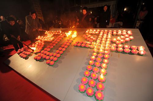 12月12日,参加仪式的和平友好人士点亮用烛光组成的“和平”两个大字。当晚,侵华日军南京大屠杀遇难同胞纪念馆和平公园内举行放和平灯仪式。100多位海内外和平友好人士、1000余名南京市青少年代表参加活动。 新华社记者 韩瑜庆 摄
