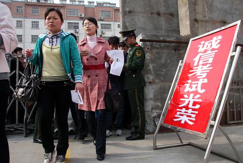 4月25日,在枣庄市鑫昌路小学的公务员招录考试考场,考生凭有效证件进场参加考试。当日,2010年山东省公务员录用考试公共科目笔试在全省17个地市同时举行。报考人数为40.8万人,比去年增长4.4%。这是山东省实行公务员考录制度以来,规模最大、人数最多的一次考试。新华社发(孙中喆 摄)